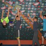 group of young male climbers striking a pose in an indoor climbing gym