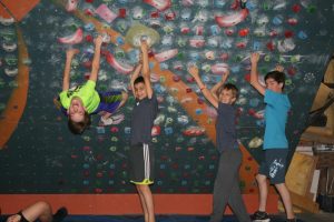 group of young male climbers striking a pose in an indoor climbing gym