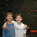 two young boys inside an indoor climbing gym