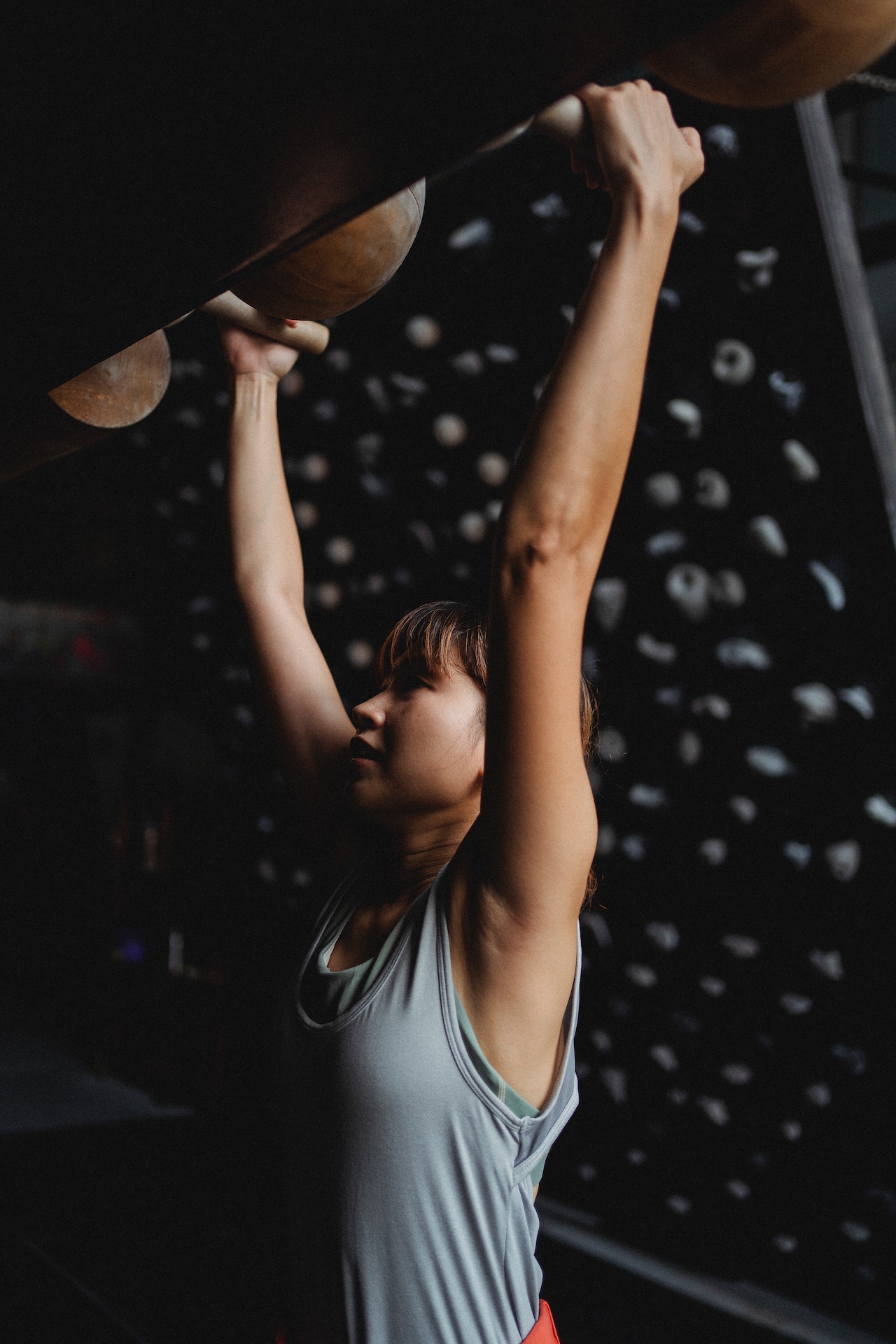 female climber hanging holding on a hold