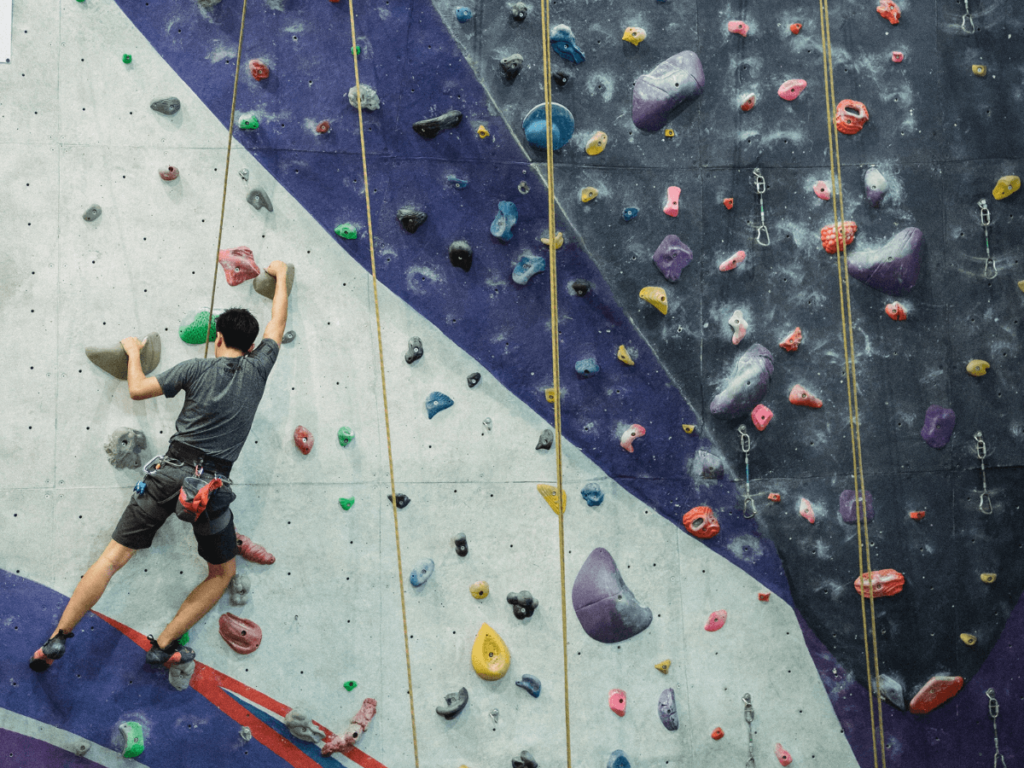 climber climbing a wall in a climbing gym