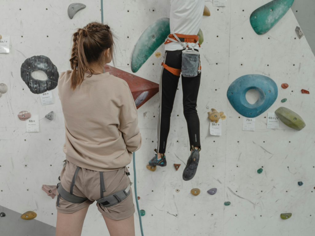 Two female climbers wears different types of pants while climbing