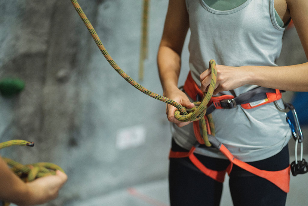 A climber fixing her harness